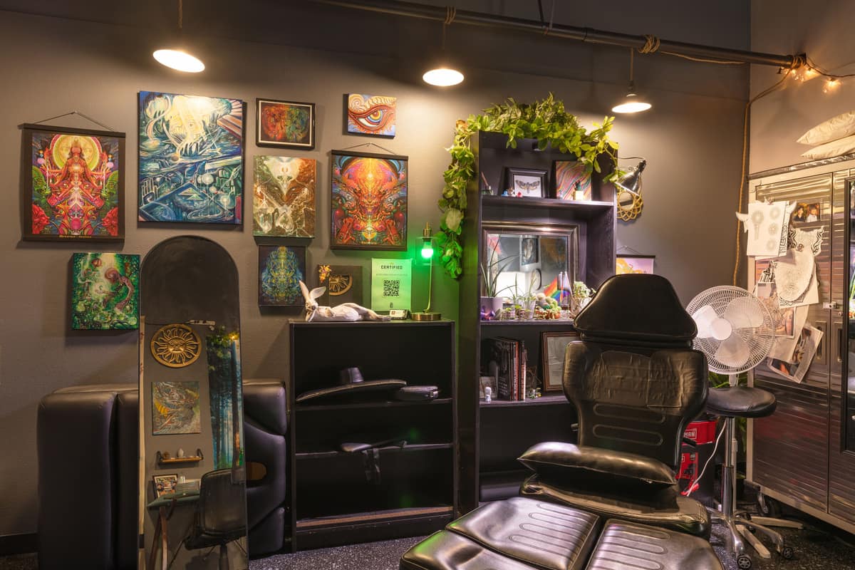 A suite covered in the artist's own art, with plants and a tattoo chair