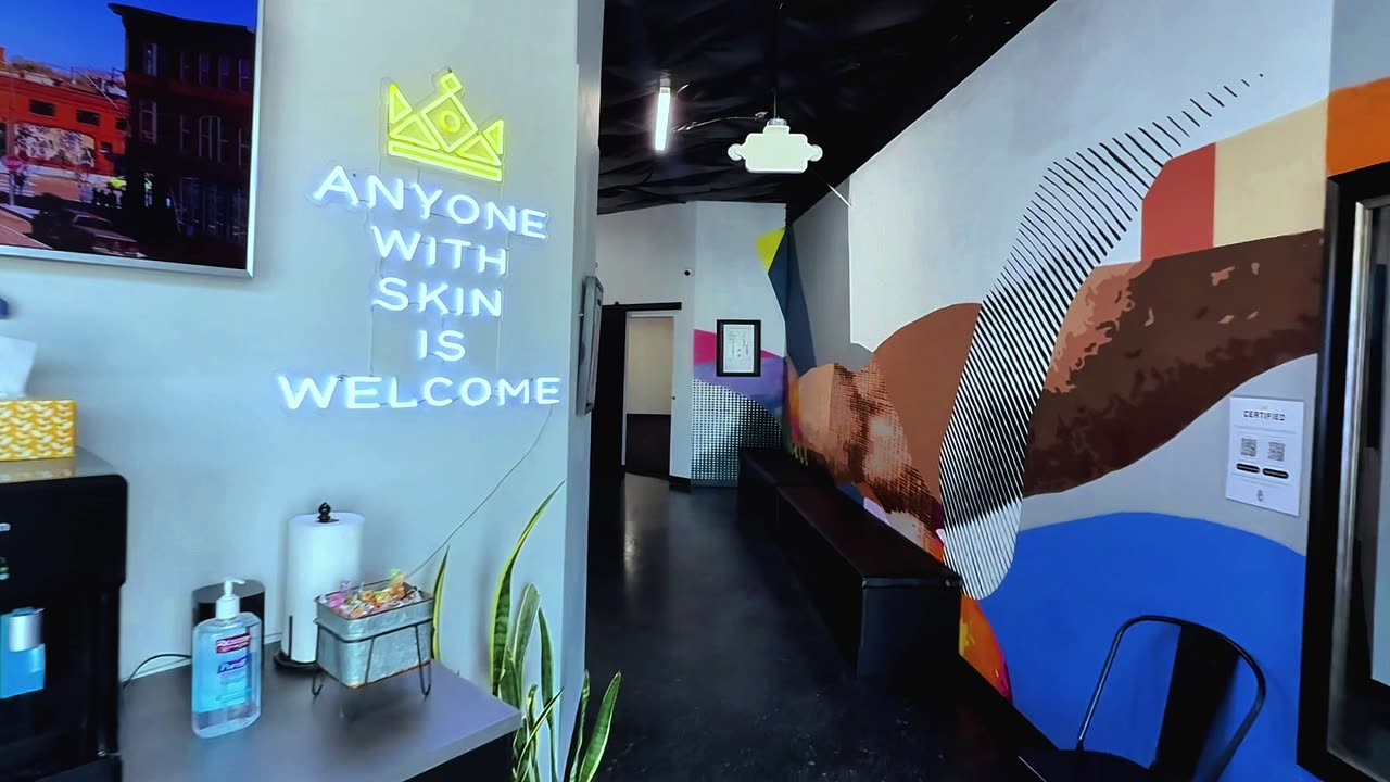 Inside the lobby at 3725 Drennan Road, under the Anyone With Skin Is Welcome sign